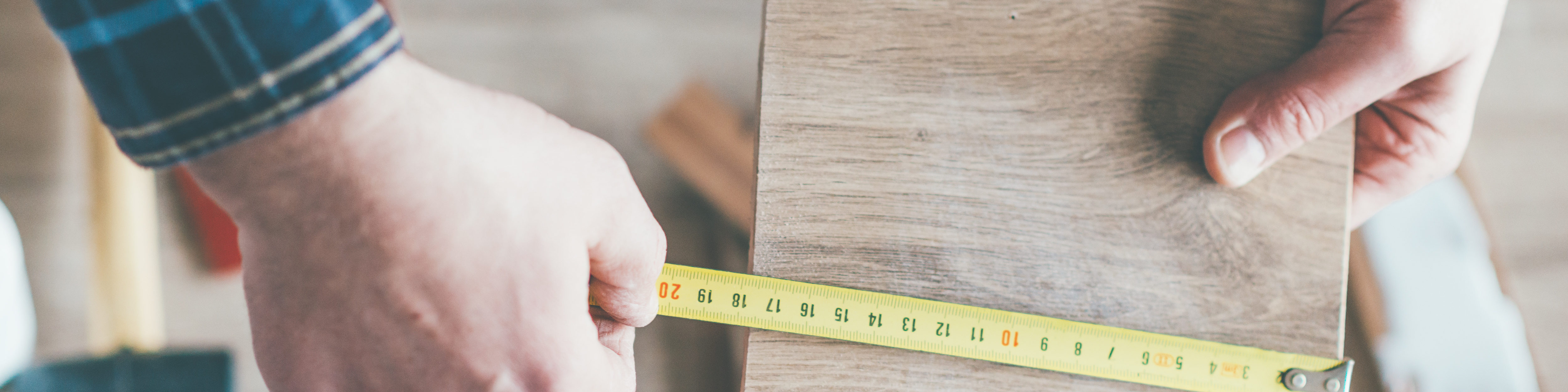 Carpenter measure wooden board in his workshop.